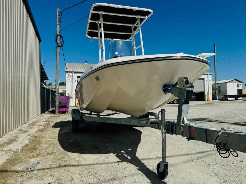 Slide: The Image of 2025 Bayliner Trophy T18 boat on trailer, parked outdoors under clear blue sky. - 3