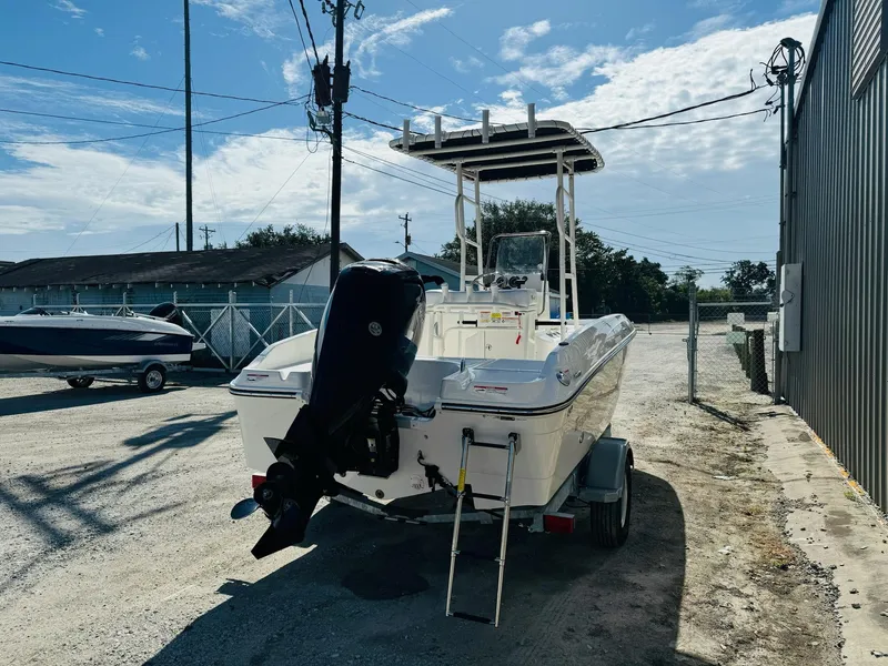Slide: The Image of 2025 Bayliner Trophy T18 boat on trailer, parked outdoors under a clear sky. - 5