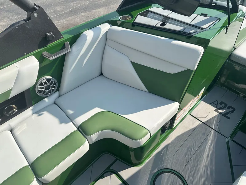 Slide: The Image of 2022 Axis A22 boat interior with green and white seating, featuring modern design and speaker system. - 12