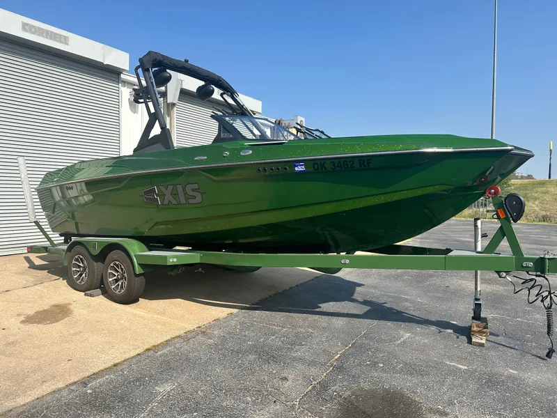 Slide: The Image of Green 2022 Axis A22 boat on trailer, parked outdoors near a building. - 5