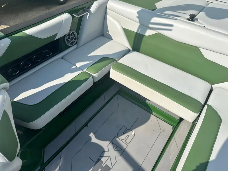 Slide: The Image of 2022 Axis A22 boat interior with green and white seating, featuring cup holders and speaker. - 7