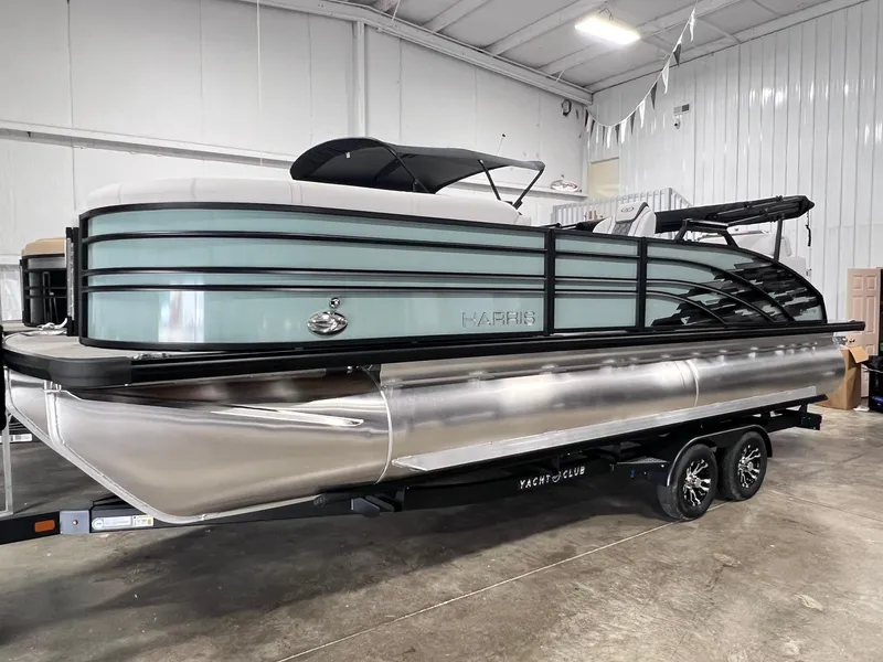 The Image of 2024 Harris Sunliner 230 pontoon boat in a showroom setting. - 0