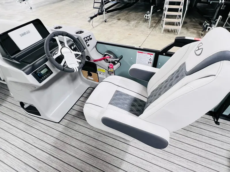 Slide: The Image of 2024 Harris Sunliner 230 boat interior with steering wheel and captain's chair. - 11