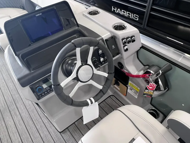 Slide: The Image of 2024 Harris Sunliner 230 boat dashboard with steering wheel and control panel. - 14