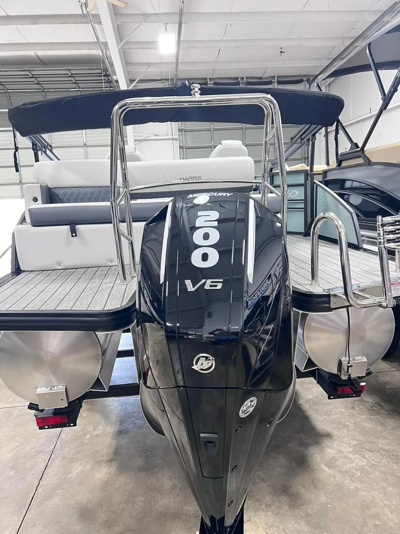 Slide: The Image of 2024 Harris Sunliner 230 pontoon boat with powerful 200 V6 engine in showroom. - 16