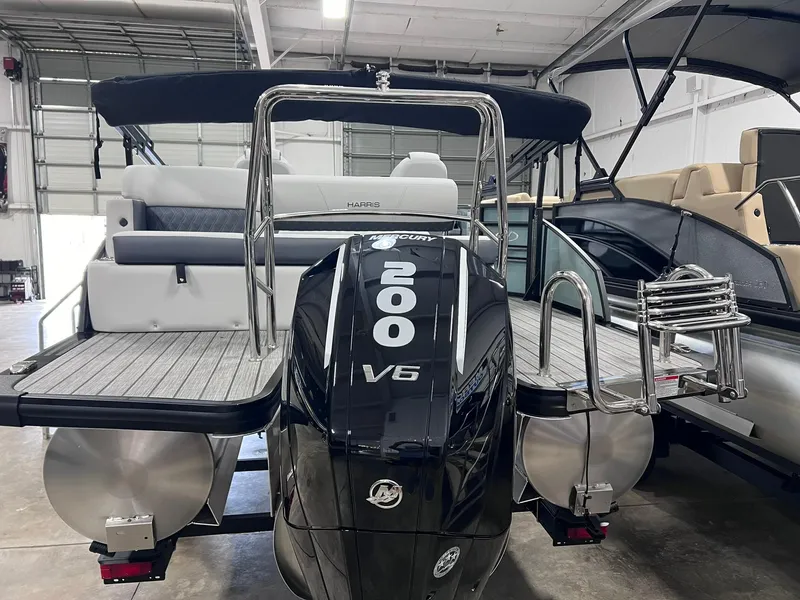Slide: The Image of 2024 Harris Sunliner 230 pontoon boat with Mercury 200 V6 engine in showroom. - 17
