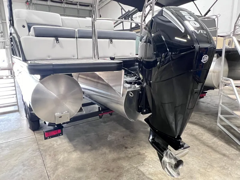 Slide: The Image of 2024 Harris Sunliner 230 pontoon boat with powerful outboard motor in a showroom. - 18