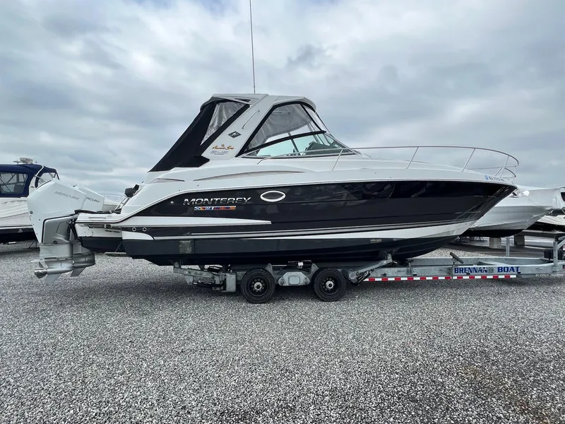 Slide: The Image of 2020 Monterey 345 SY boat on trailer, parked on gravel lot under cloudy sky. - 39