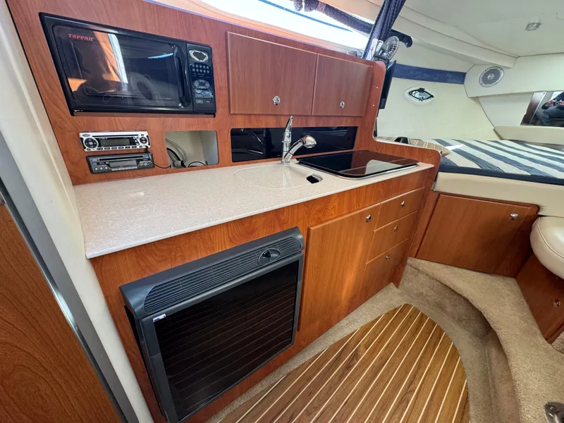 Slide: The Image of 2008 Bayliner 300 Ciera interior kitchen with wood cabinetry and modern appliances. - 21