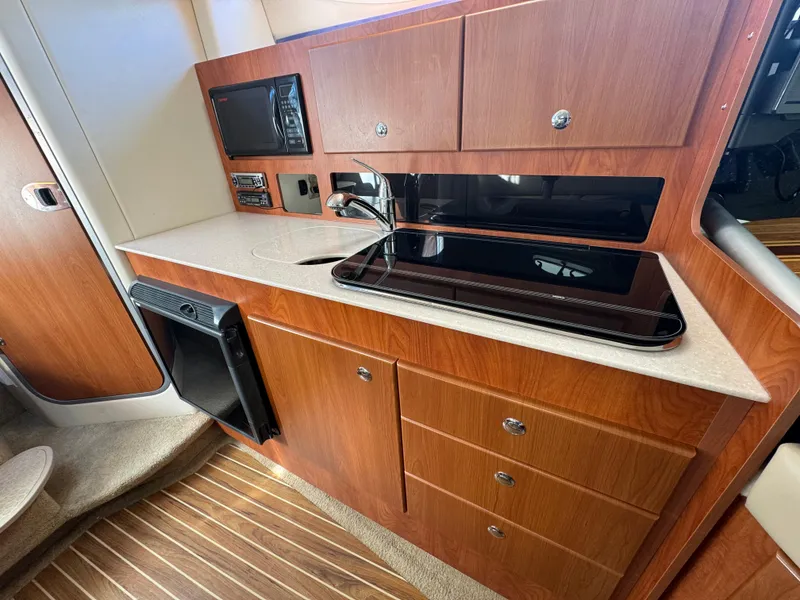 Slide: The Image of 2008 Bayliner 300 Ciera interior kitchen with wood cabinets and modern appliances. - 22