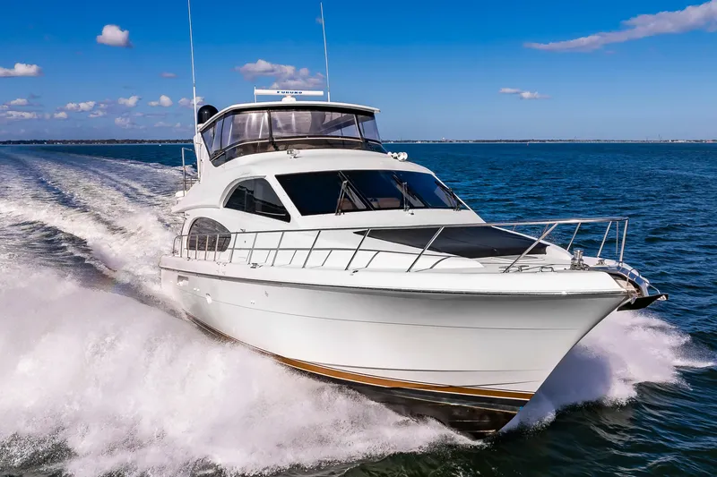 Slide: The Image of 2007 Hatteras 64 Motor Yacht cruising on open water under clear skies. - 0