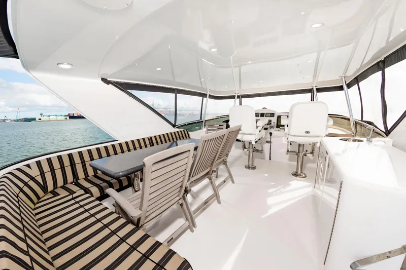 Slide: The Image of Luxurious 2007 Hatteras 64 Motor Yacht interior with seating and helm, overlooking the water. - 14