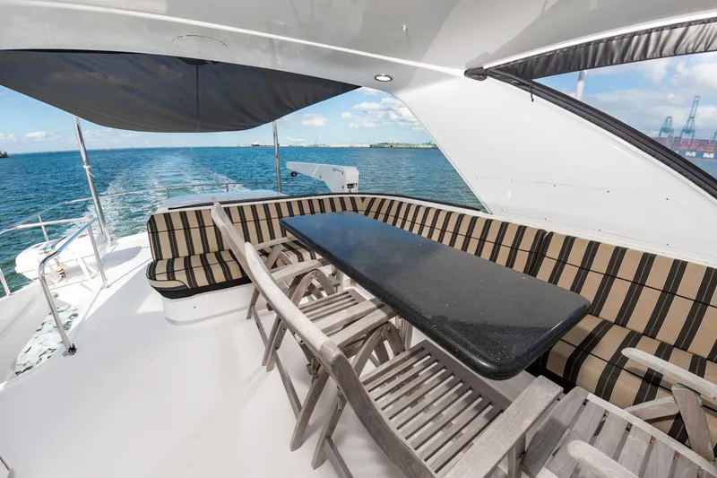 Slide: The Image of Luxurious 2007 Hatteras 64 Motor Yacht deck with seating and ocean view. - 16