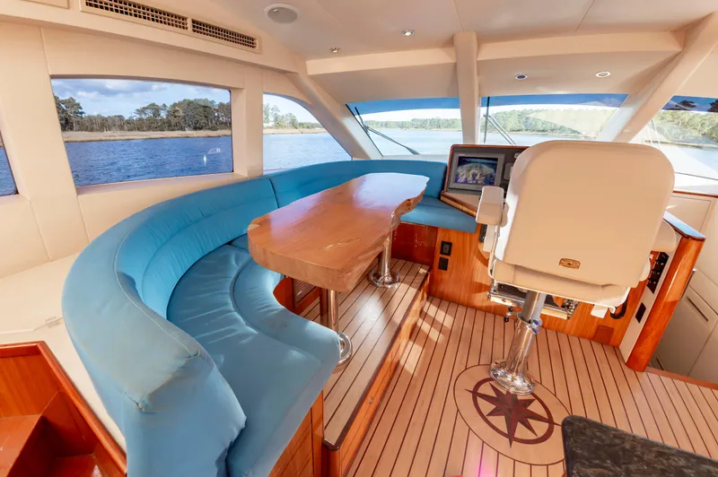 Slide: The Image of Luxurious interior of 2007 Hatteras 64 Motor Yacht with blue seating and wooden accents. - 30