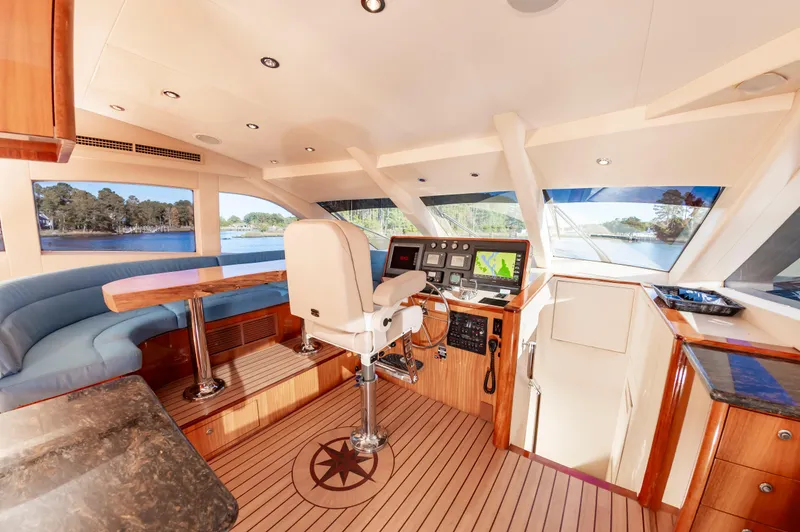 Slide: The Image of Luxurious 2007 Hatteras 64 Motor Yacht helm with panoramic windows and elegant wood finishes. - 34