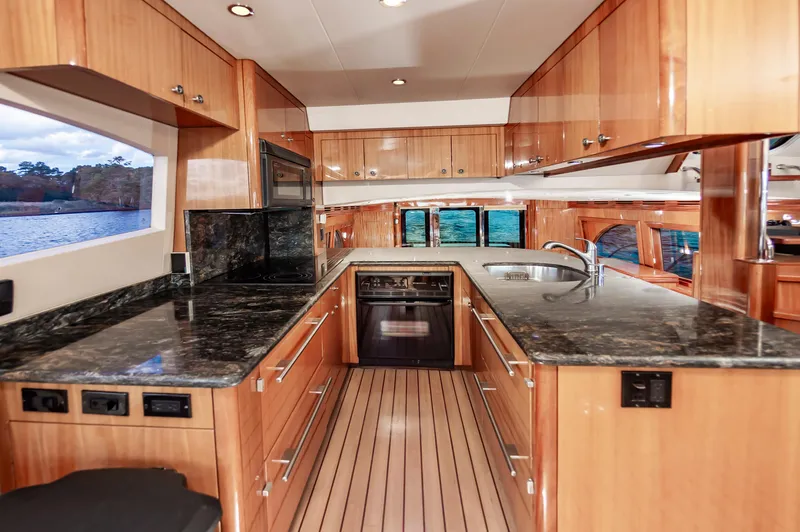 Slide: The Image of Luxurious kitchen interior of 2007 Hatteras 64 Motor Yacht with wood cabinetry and granite countertops. - 38
