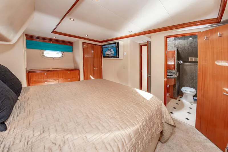 Slide: The Image of Luxurious bedroom and bathroom in 2007 Hatteras 64 Motor Yacht, featuring elegant wood finishes. - 42