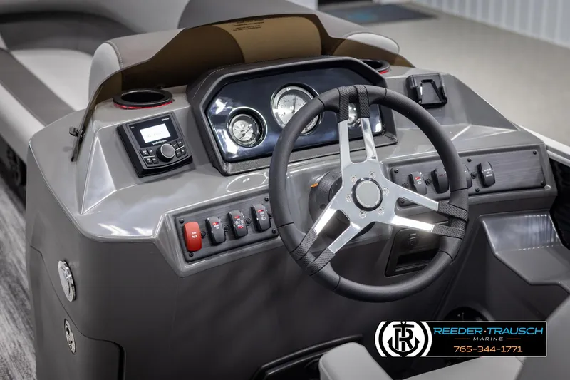 Slide: The Image of 2025 Bennington 21 SLSE boat dashboard with steering wheel and control panel, Reeder-Trausch Marine branding. - 27