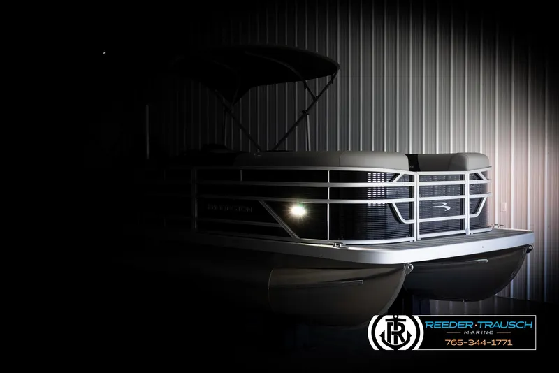 Slide: The Image of 2025 Bennington 21 SLSE pontoon boat in dimly lit showroom, highlighting sleek design. - 4