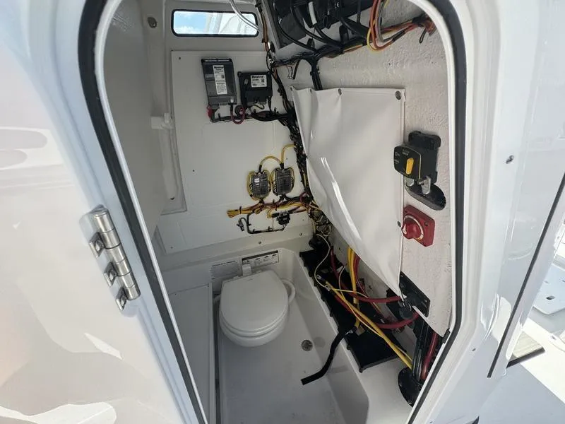 Slide: The Image of 2025 Sportsman Heritage 231 boat interior wiring and storage compartment. - 15