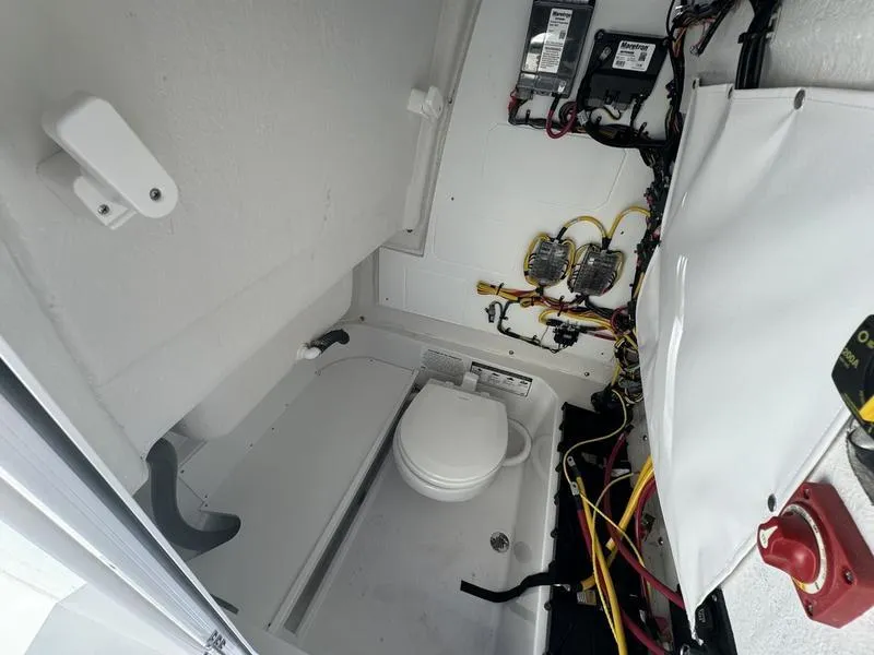Slide: The Image of 2025 Sportsman Heritage 231 boat interior with toilet and electrical components. - 16