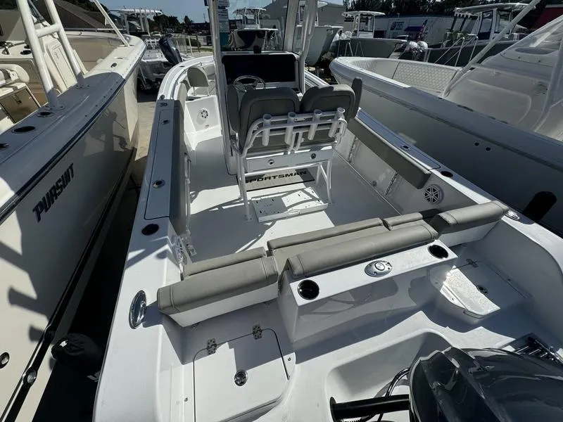 Slide: The Image of 2025 Sportsman Heritage 231 boat interior with seating and console, docked among other boats. - 21