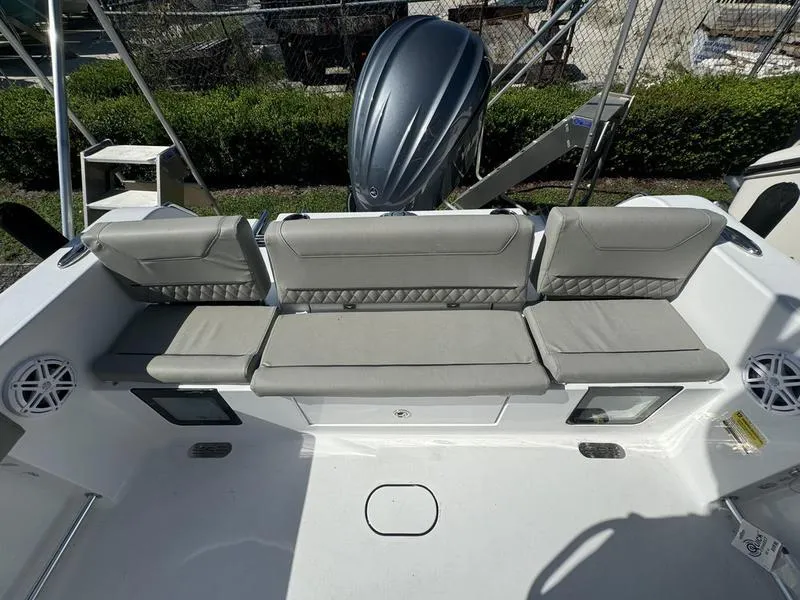 Slide: The Image of 2025 Sportsman Heritage 231 boat with cushioned seating and outboard motor. - 28