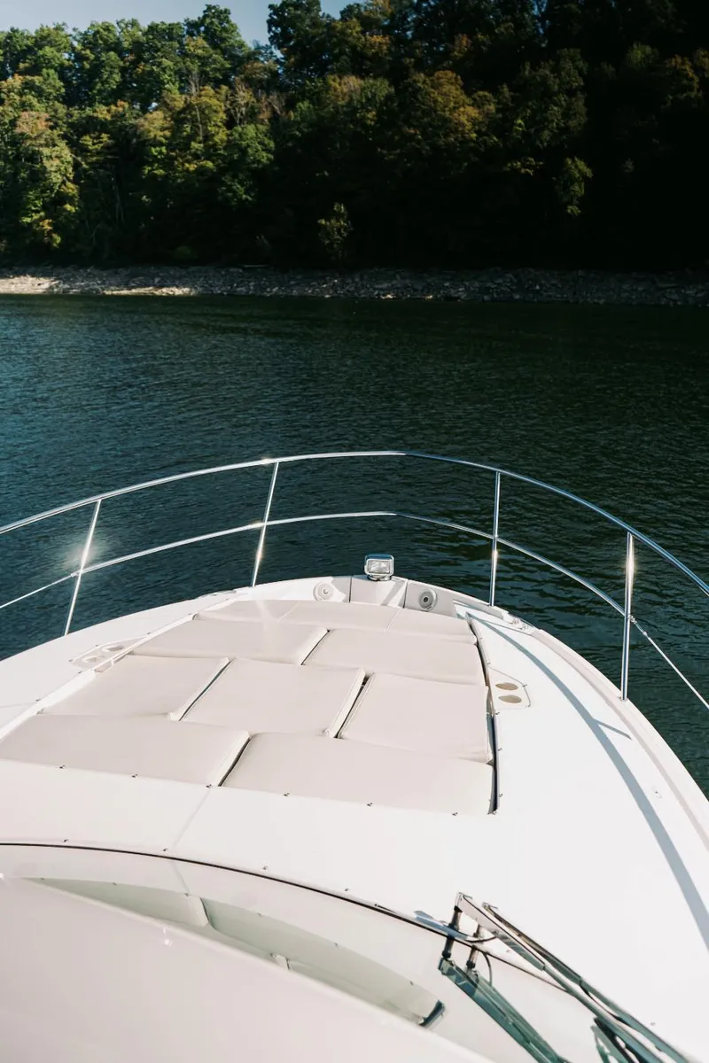 Slide: The Image of 2021 Regal 38 Grande Coupe yacht on serene water with lush forest backdrop. - 18