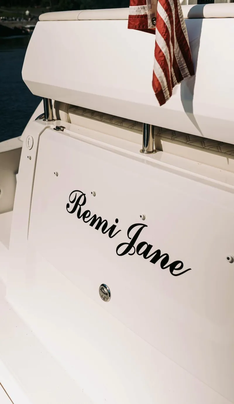 Slide: The Image of 2021 Regal 38 Grande Coupe yacht with "Remi Jane" name and American flag. - 20