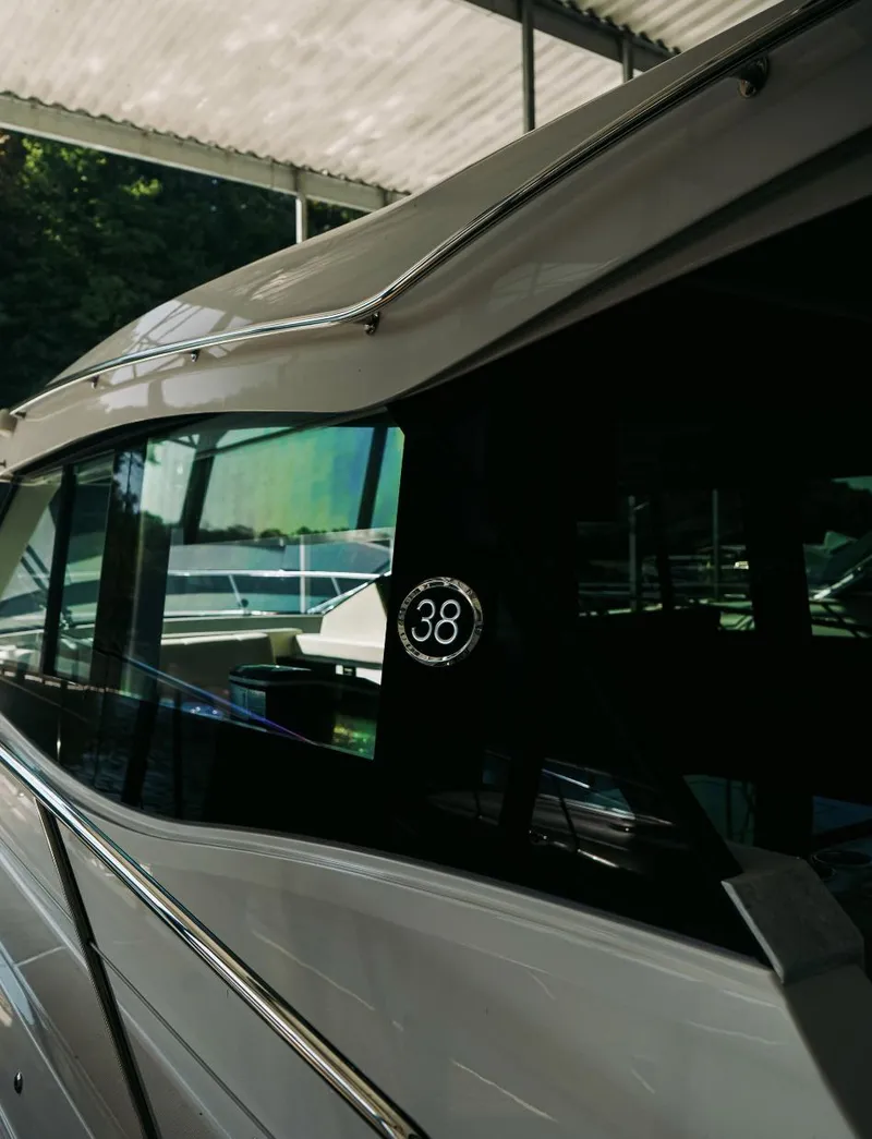 Slide: The Image of 2021 Regal 38 Grande Coupe yacht under a canopy, showcasing sleek design and modern features. - 25