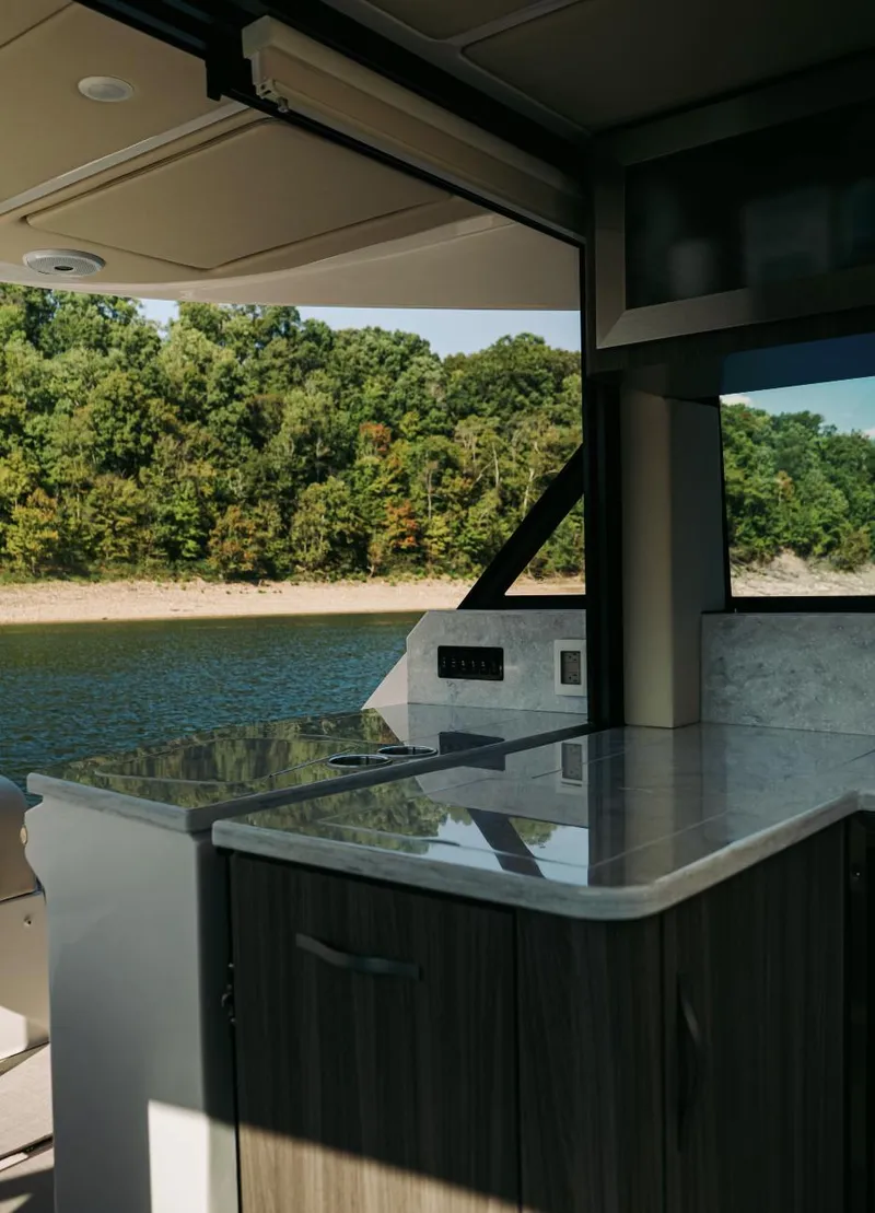 Slide: The Image of 2021 Regal 38 Grande Coupe interior with lake view and modern kitchen design. - 8