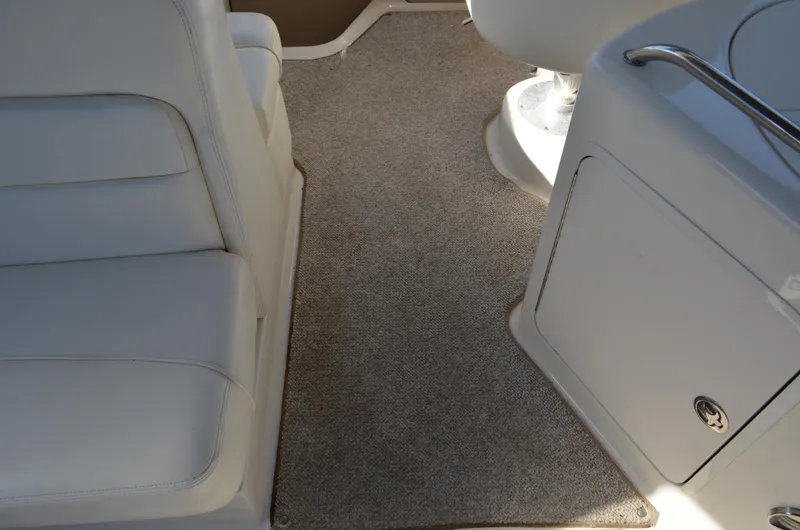 Slide: The Image of 2004 Sea Ray 280 Sundancer interior with white seating and carpeted flooring. - 12