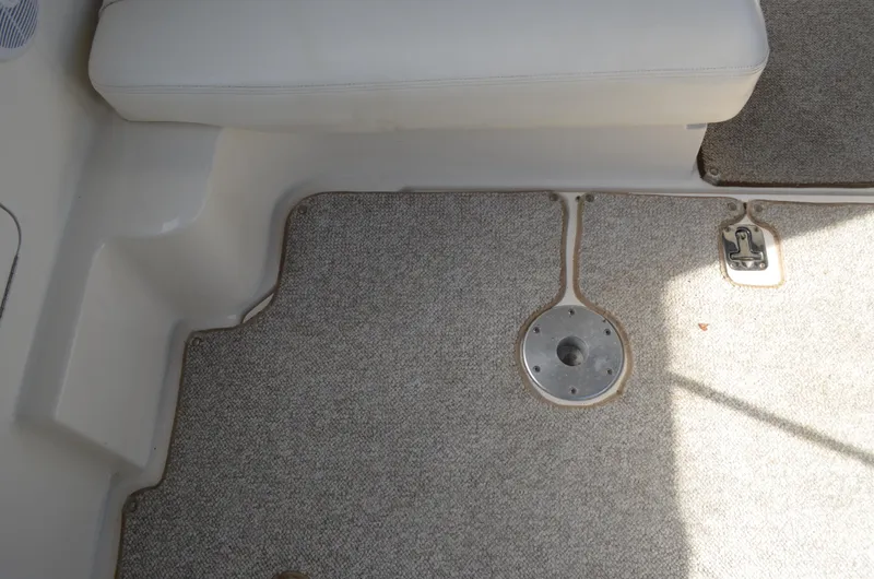 Slide: The Image of 2004 Sea Ray 280 Sundancer interior with carpeted floor and seating area. - 13