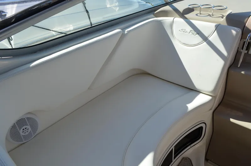 Slide: The Image of Interior seating of 2004 Sea Ray 280 Sundancer boat, featuring white upholstery and cup holders. - 15