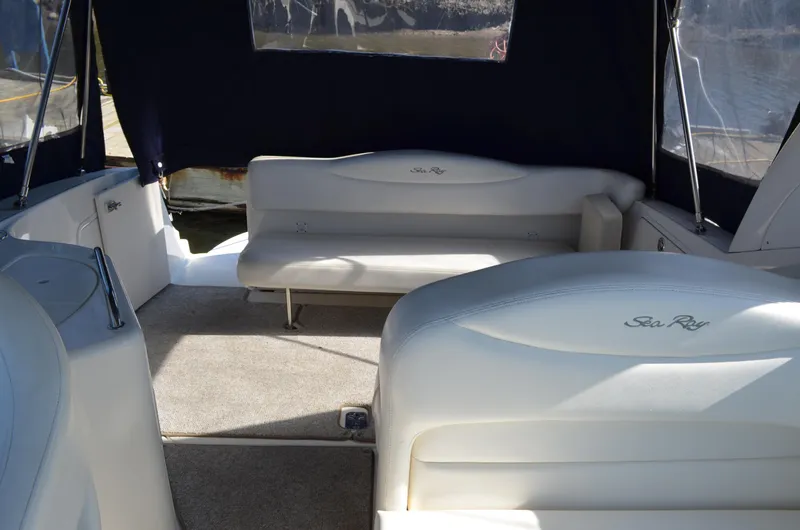 Slide: The Image of Interior of 2004 Sea Ray 280 Sundancer boat with white seating and dark canopy. - 17