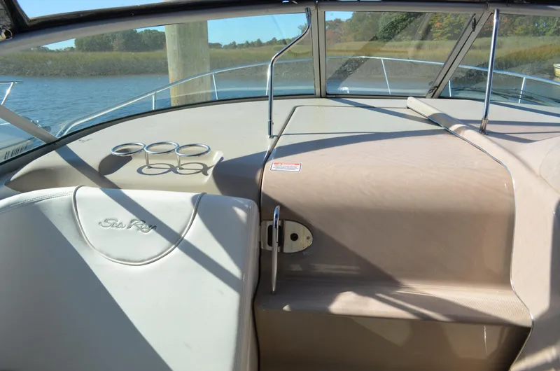 Slide: The Image of 2004 Sea Ray 280 Sundancer boat interior with cup holders and windshield view. - 18
