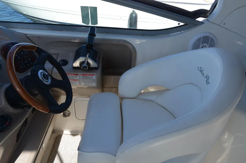 Slide: The Image of 2004 Sea Ray 280 Sundancer helm with steering wheel and white captain's chair. - 19