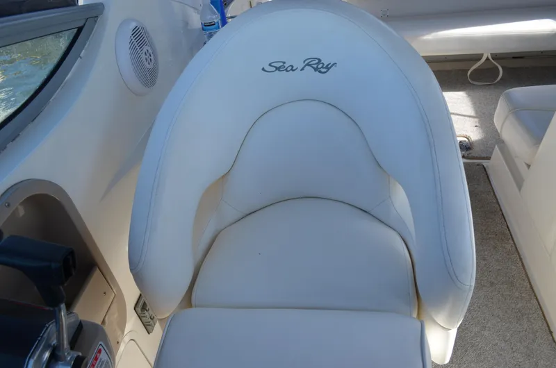 Slide: The Image of 2004 Sea Ray 280 Sundancer boat seat with logo, featuring white upholstery and cockpit details. - 20