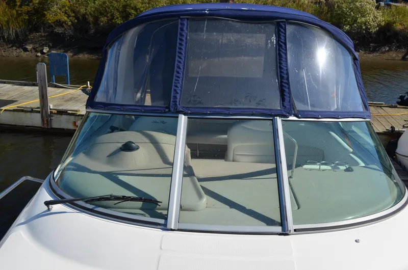 Slide: The Image of 2004 Sea Ray 280 Sundancer boat docked with blue canopy and windshield. - 26