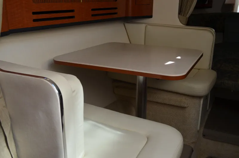 Slide: The Image of Interior of 2004 Sea Ray 280 Sundancer with dining area and cushioned seating. - 28