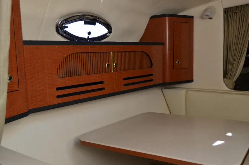 Slide: The Image of 2004 Sea Ray 280 Sundancer cabin interior with wood cabinetry and table. - 29