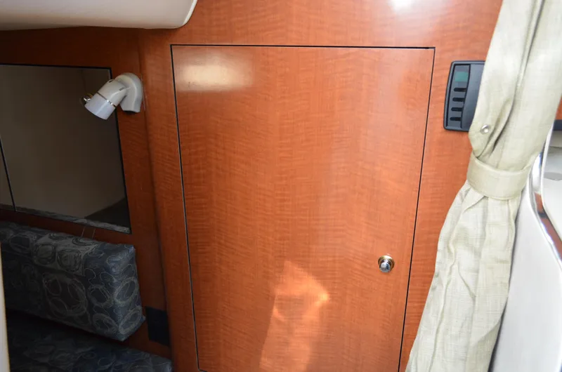Slide: The Image of Interior cabin of 2004 Sea Ray 280 Sundancer with wood paneling and seating. - 32