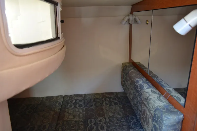 Slide: The Image of 2004 Sea Ray 280 Sundancer cabin interior with patterned seating and mirrored wall. - 34
