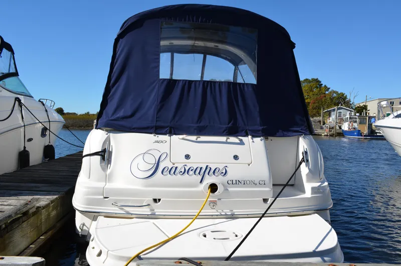 Slide: The Image of 2004 Sea Ray 280 Sundancer docked, rear view with blue cover, named "Seascapes." - 4