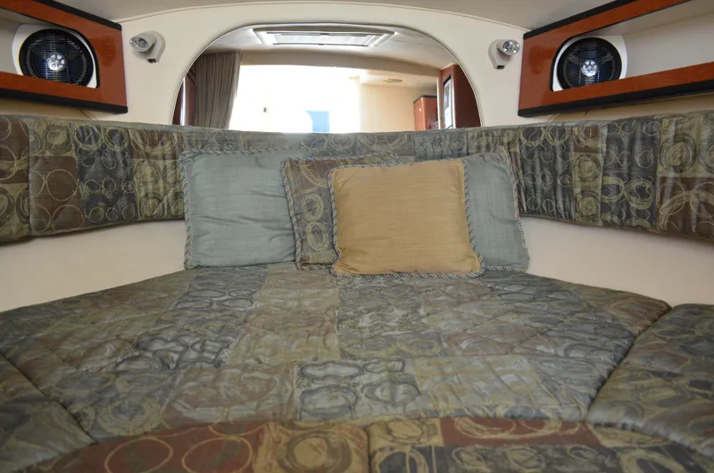 Slide: The Image of Interior cabin of 2004 Sea Ray 280 Sundancer with patterned bedding and pillows. - 43