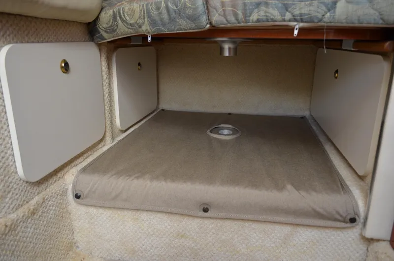 Slide: The Image of 2004 Sea Ray 280 Sundancer cabin storage area with cushioned seating. - 44