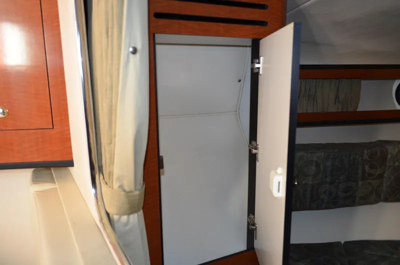 Slide: The Image of 2004 Sea Ray 280 Sundancer interior cabin with open storage compartment. - 48