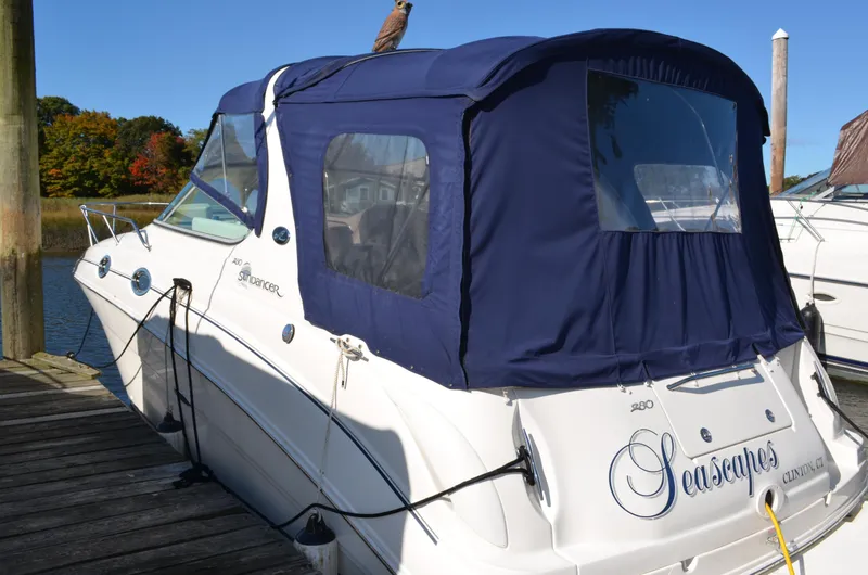 Slide: The Image of 2004 Sea Ray 280 Sundancer docked with blue canopy, rear view. - 5
