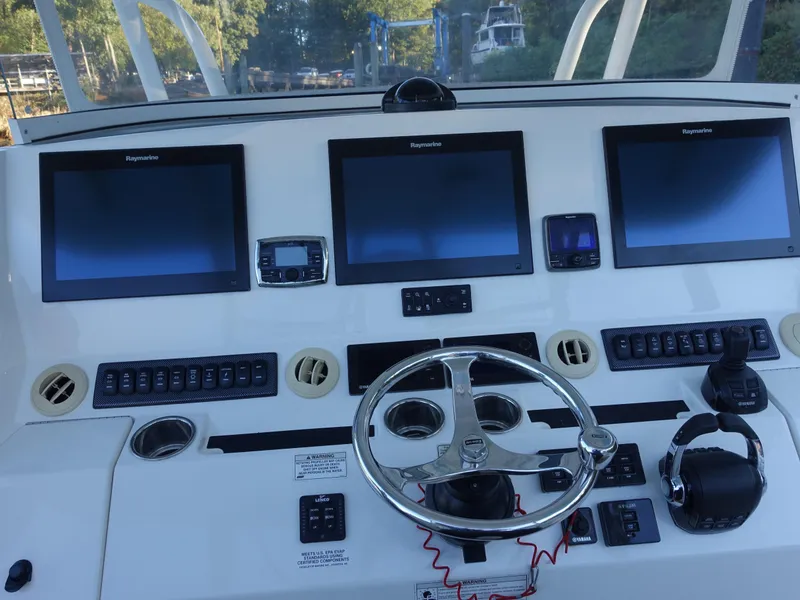 Slide: The Image of Control panel of a 2016 Regulator 41 boat with multiple screens and steering wheel. - 14