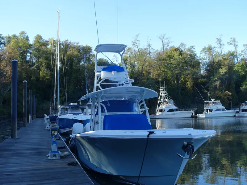 Slide: The Image of 2016 Regulator 41 boat docked at marina with surrounding trees and calm water. - 30
